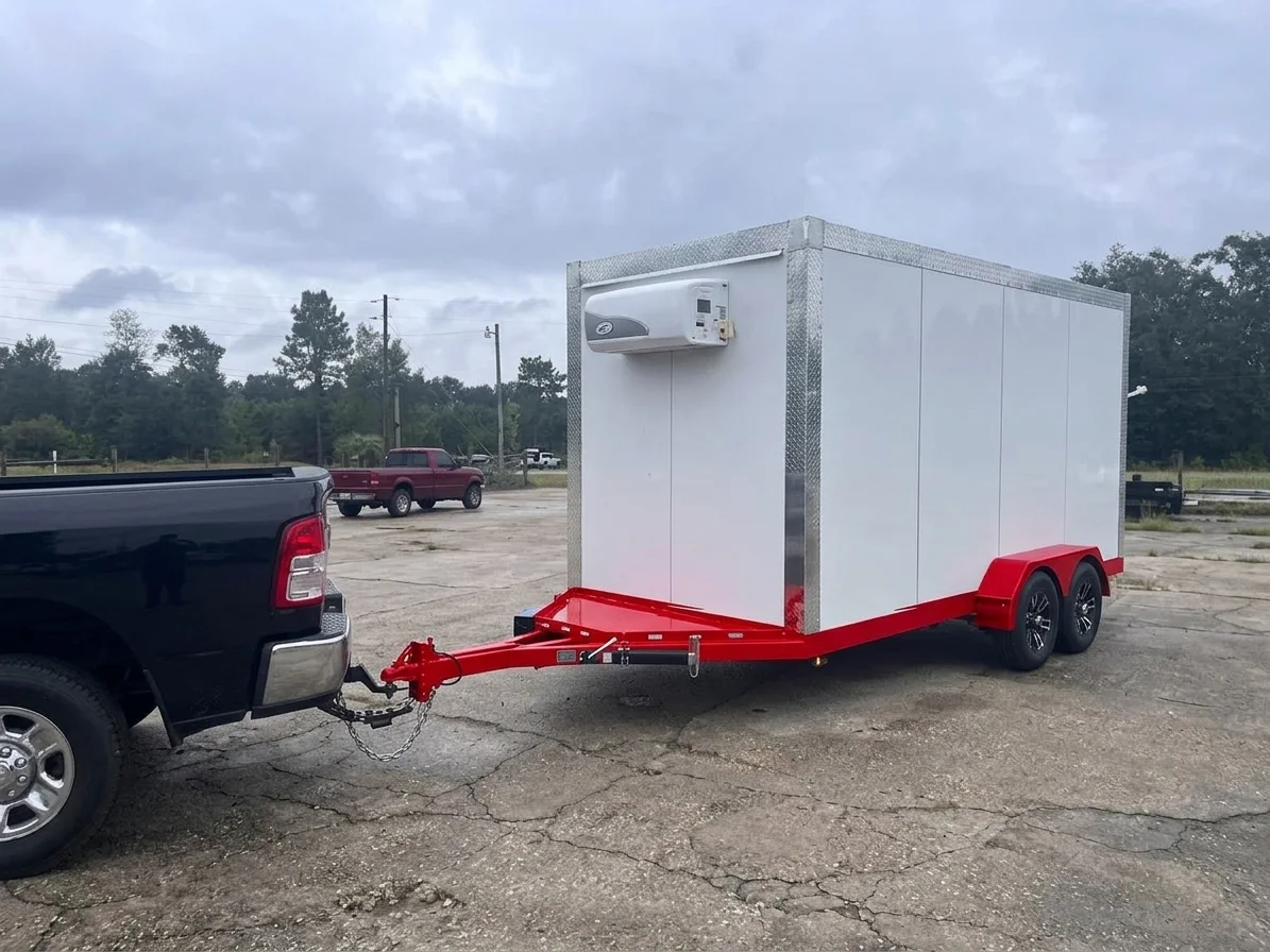 RTD refrigerated trailer with white panels and a red frame, hitched to a black pickup truck